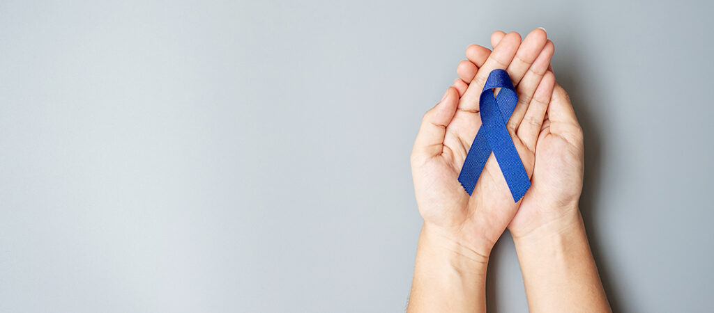 Main ouverte avec un ruban bleu pour le prévention contre le cancer colorectal